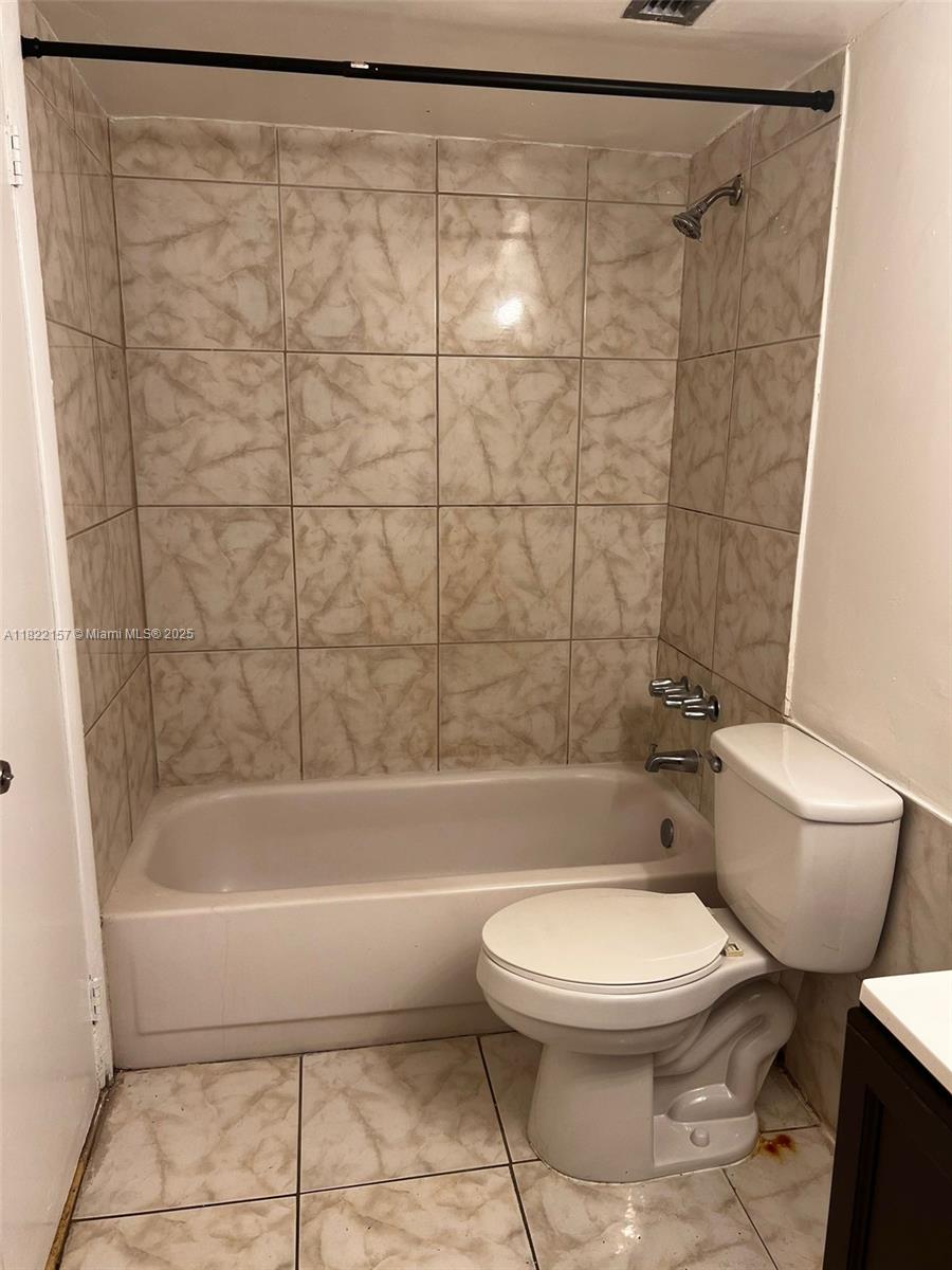 A bathroom features a tiled shower-tub combination and a white toilet — 498 NW 165th St Rd # D303, Miami FL 33169, MIAMI, FL