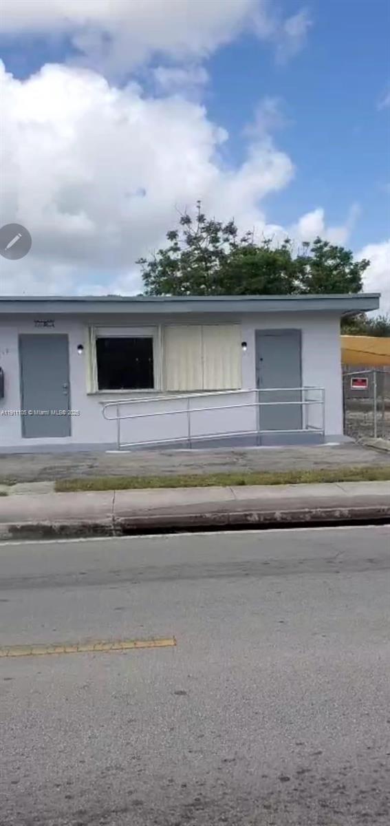 A single-story building exterior features two gray doors, a window, and a metal wheelchair ramp — 512 SW 6th Ave, Homestead FL 33030, HOMESTEAD, FL