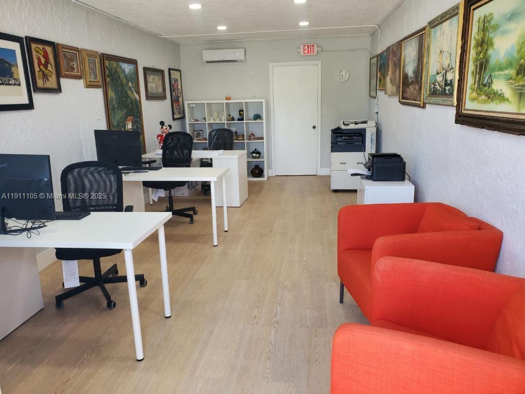 An office space features white desks, red armchairs, wall-mounted paintings, and light wood-look flooring — 512 SW 6th Ave, Homestead FL 33030, HOMESTEAD, FL