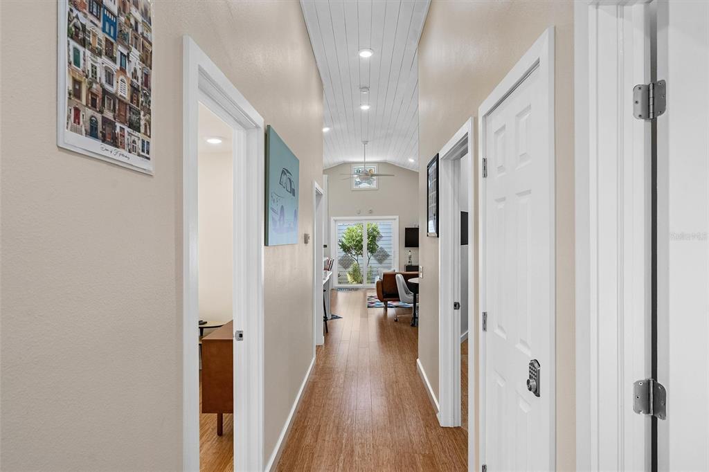 A hallway with wood-look flooring leads to a living area with a vaulted ceiling — 1500 9TH AVENUE N, ST PETERSBURG, FL