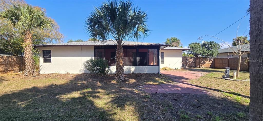 The exterior of a single-story house features a screened-in porch, palm trees, and a patio — 2395 ALDA LANE, PORT CHARLOTTE, FL