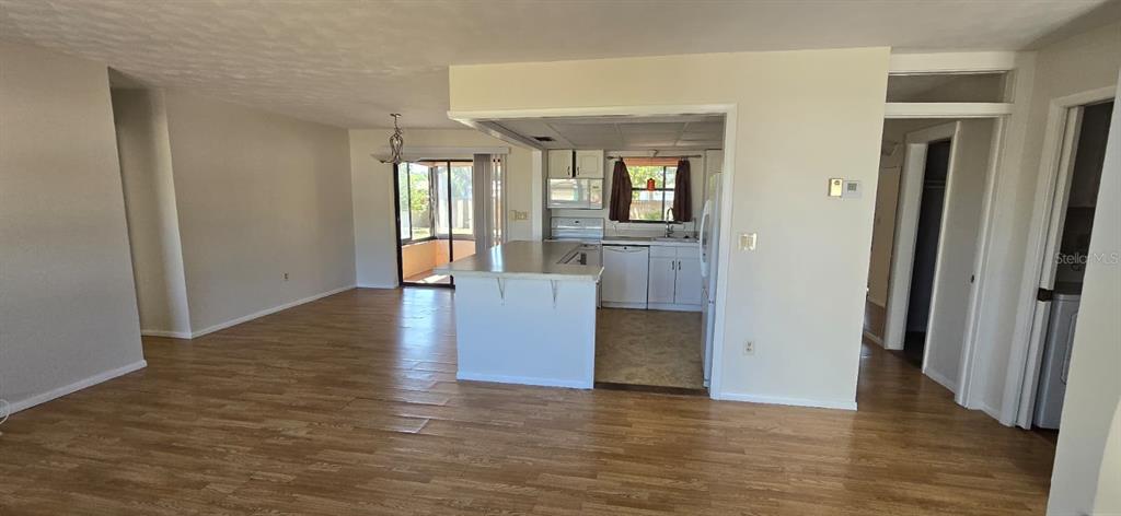 An open-concept kitchen with a central island overlooks a living area and sunroom — 2395 ALDA LANE, PORT CHARLOTTE, FL