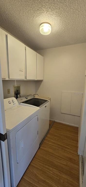 A laundry room features white cabinets, a washer and dryer, and light wood-look flooring — 2395 ALDA LANE, PORT CHARLOTTE, FL
