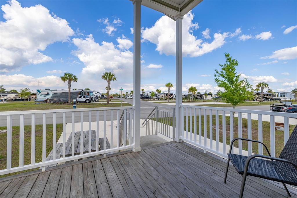 A wooden deck with a railing overlooks a paved road and several parked RVs — 325 TIKI TURN (HWY 630) E, LAKE WALES, FL