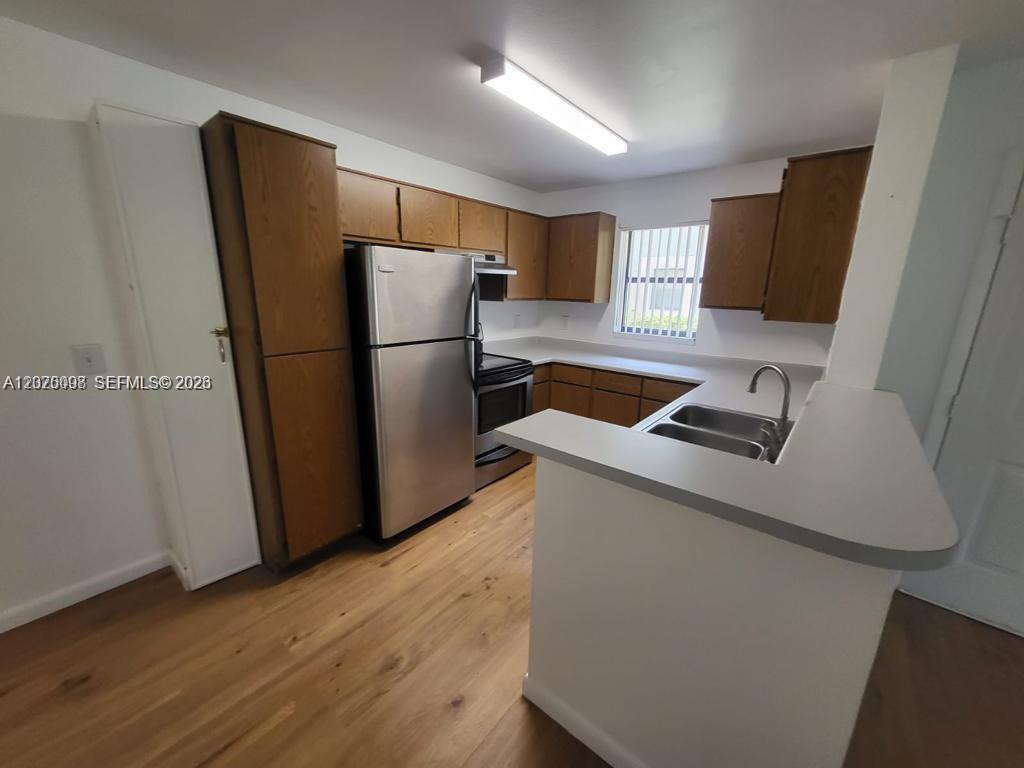 A kitchen features wood cabinets, stainless steel appliances, a double sink, and light-colored countertops — 4028 NW 87th Ave # 4028, Sunrise FL 33351, SUNRISE, FL