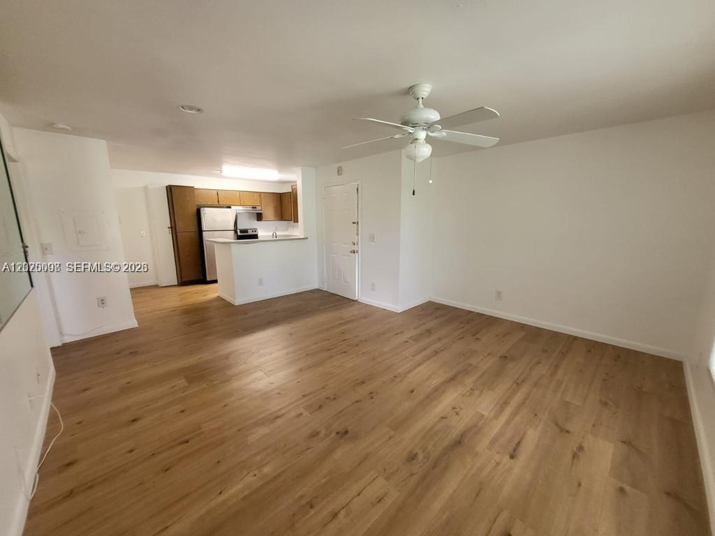 An open-concept living area features light wood-look flooring, a ceiling fan, and an adjacent kitchen — 4028 NW 87th Ave # 4028, Sunrise FL 33351, SUNRISE, FL