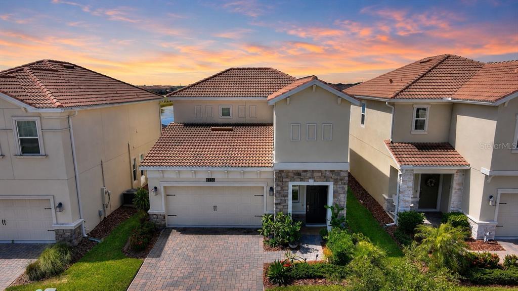 An aerial view of a two-story suburban house with a tiled roof and driveway — 8736 PACIFIC DUNES DR, DAVENPORT, FL