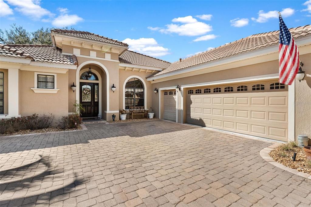 A single-story house with a paved driveway, a three-car garage, and a tiled roof — 26309 SAN GABRIEL, HOWEY IN THE HILLS, FL