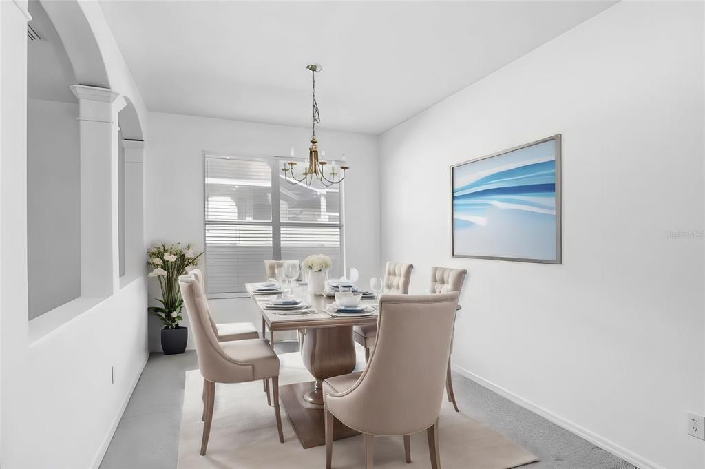 A dining room features a wooden table with six upholstered chairs under a chandelier — 2927 MINUTEMAN LANE, BRANDON, FL