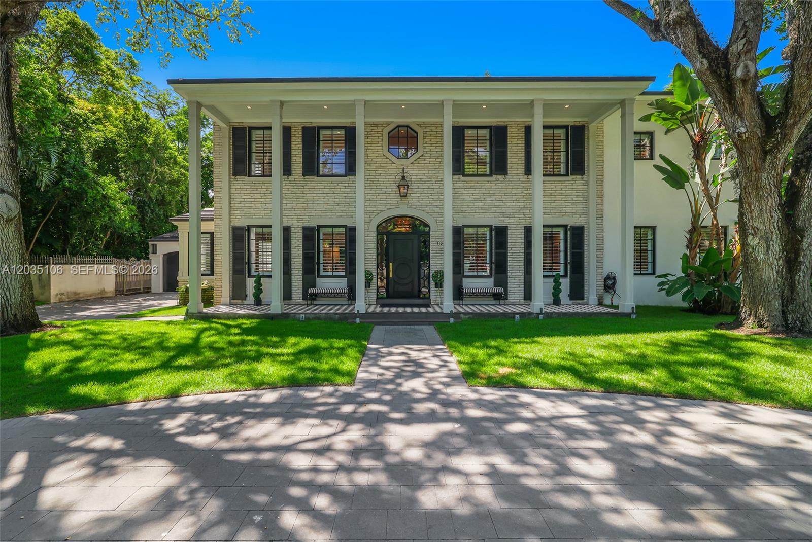 A two-story colonial-style house features a brick facade, white columns, and a paved driveway — 3120 Brickell Ave, Miami FL 33129, MIAMI, FL