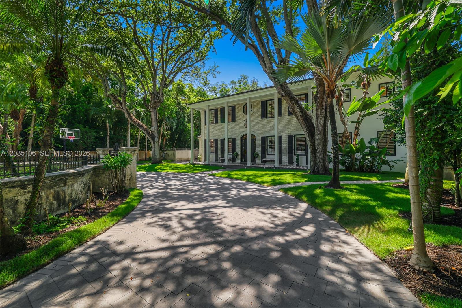 A two-story colonial-style house with a brick facade sits behind a paved driveway and trees — 3120 Brickell Ave, Miami FL 33129, MIAMI, FL