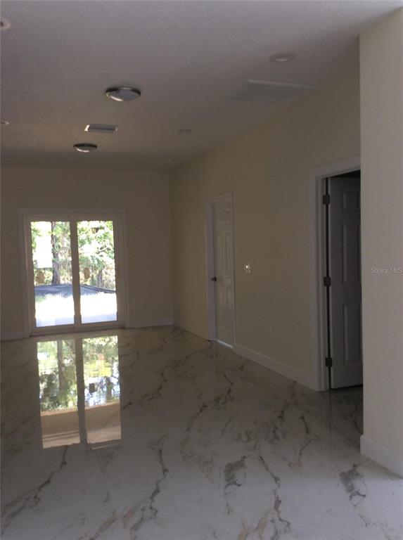 An interior room features white marble-look tile flooring, recessed lighting, and sliding glass doors — 2812 DURHAM STREET, TAMPA, FL