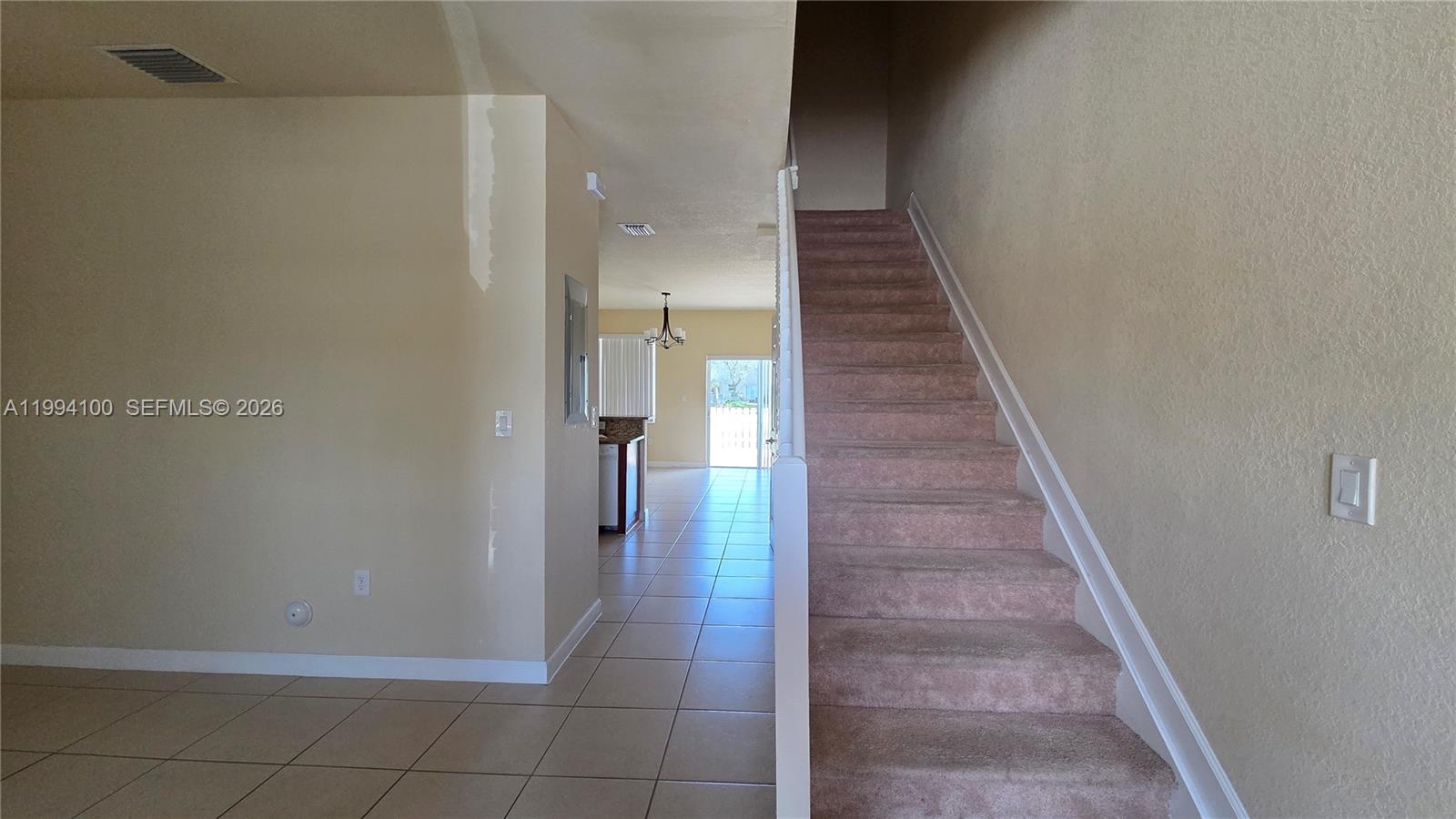 An interior view shows a carpeted staircase next to a tiled hallway leading to a kitchen — 9001 SW 227th St # 7, Cutler Bay FL 33190, CUTLER BAY, FL
