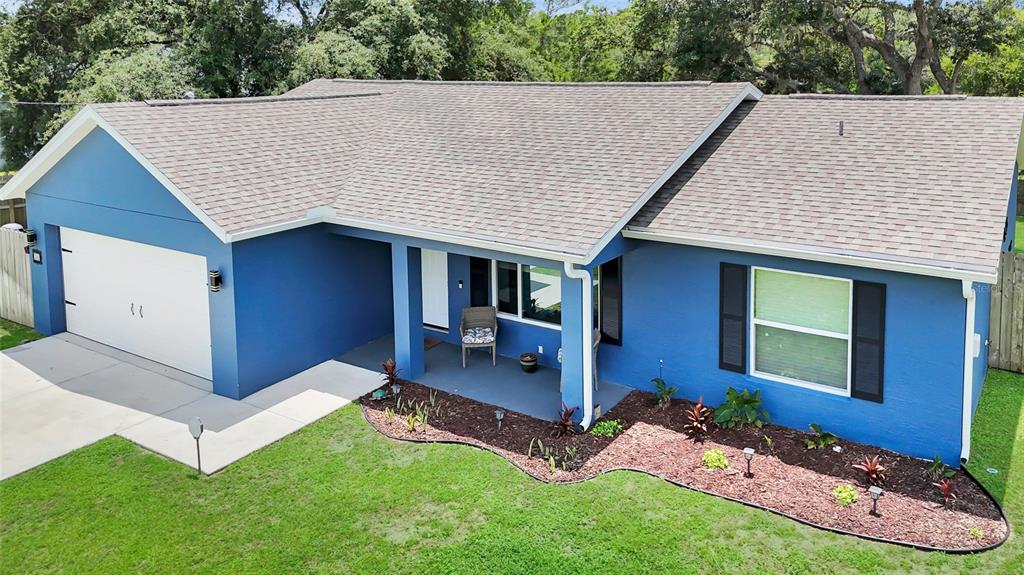 An aerial view of a blue single-story house with a white garage and front porch — 20 MALAUKA CIRCLE, OCKLAWAHA, FL