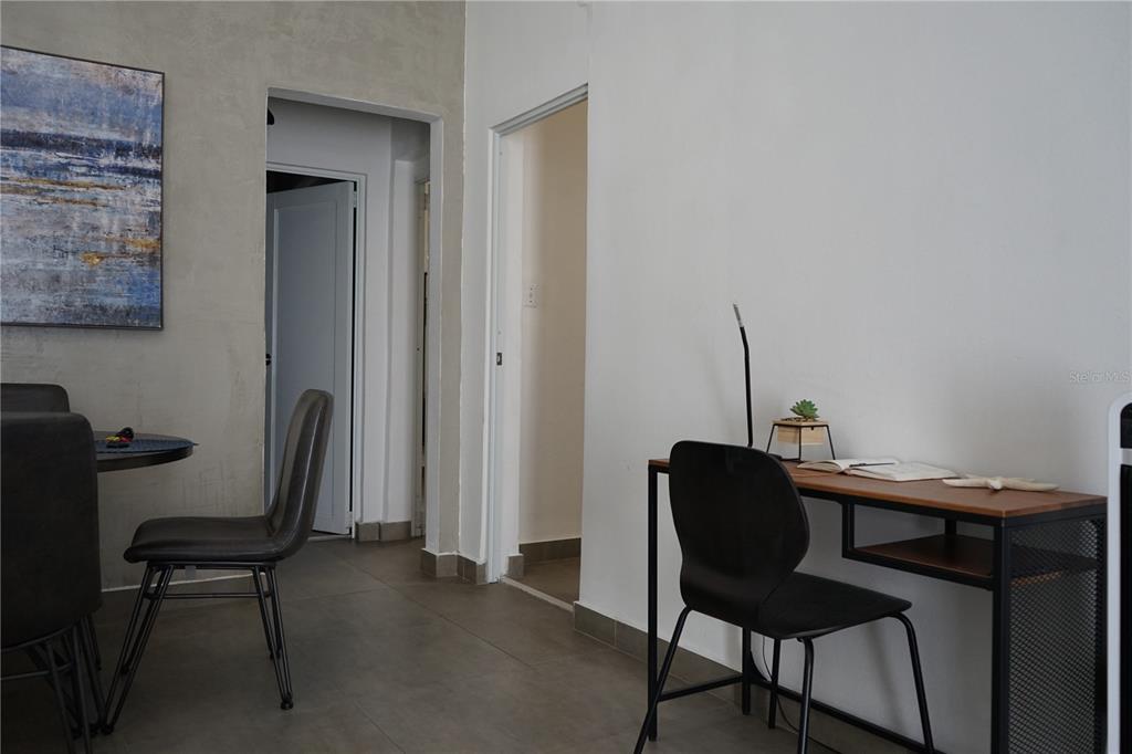 A room features a dining area with a table and chairs beside a small desk — 117 CALLE POMARROSA UNIT 3D, SAN JUAN, PR