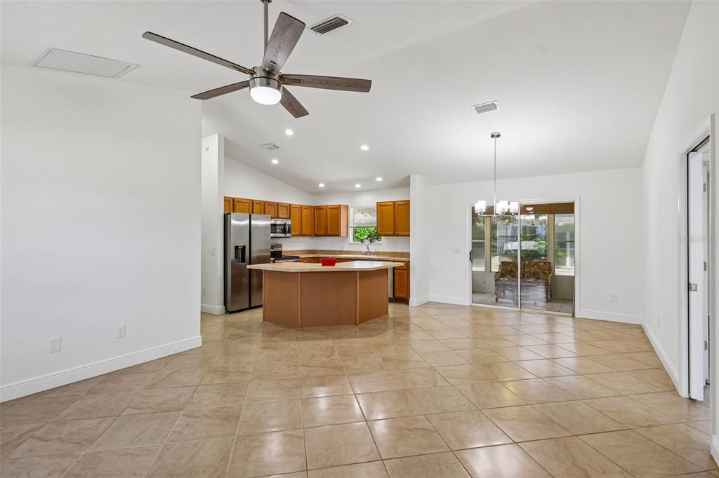 An open-concept kitchen and dining area features tile flooring, wood cabinets, and a ceiling fan — 1000 KENOVA AVENUE, THE VILLAGES, FL