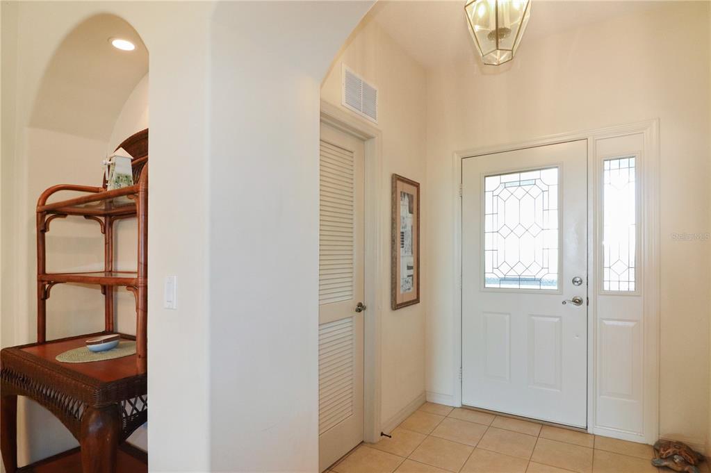An entryway features a white front door with glass panels, tile flooring, and a shelf — 20846 QUEEN ALEXANDRA DRIVE, LEESBURG, FL