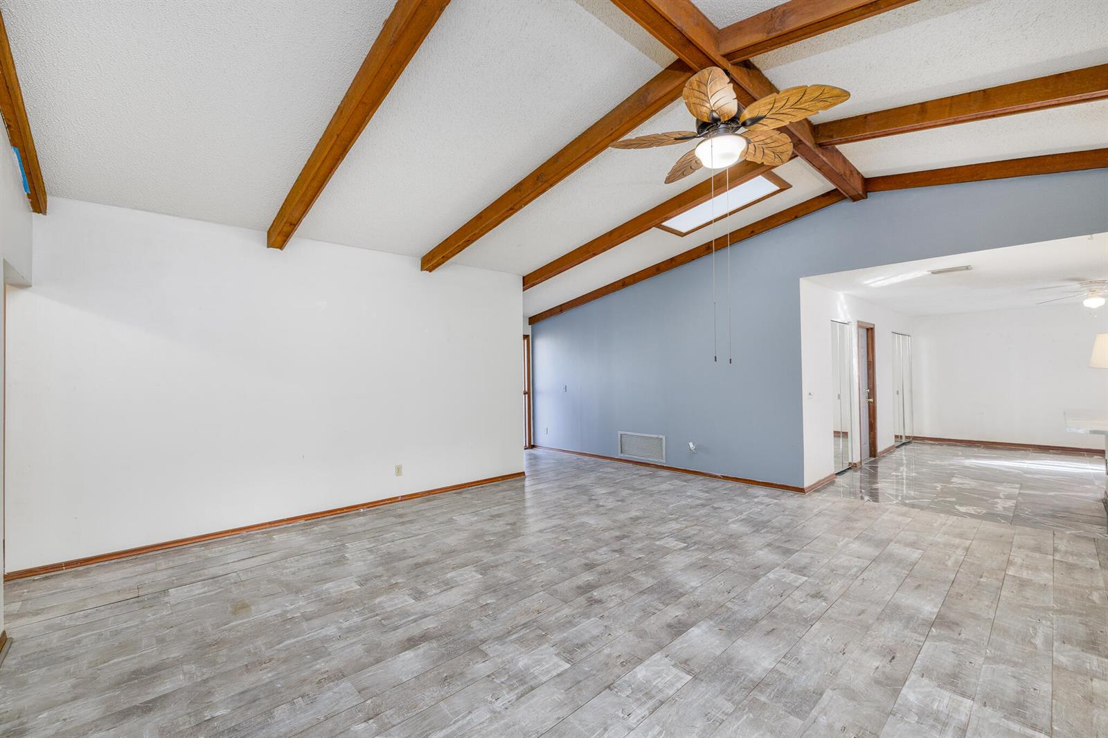 A living room with vaulted ceilings, exposed wood beams, a ceiling fan, and gray flooring — 4262 S Centennial Avenue, FL 34446, FL