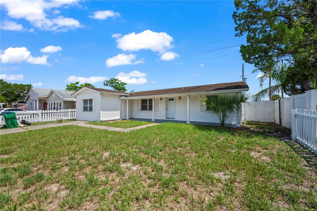 A white single-story house with a covered porch and a fenced front yard — 405 N HAWTHORN CIRCLE, WINTER SPRINGS, FL