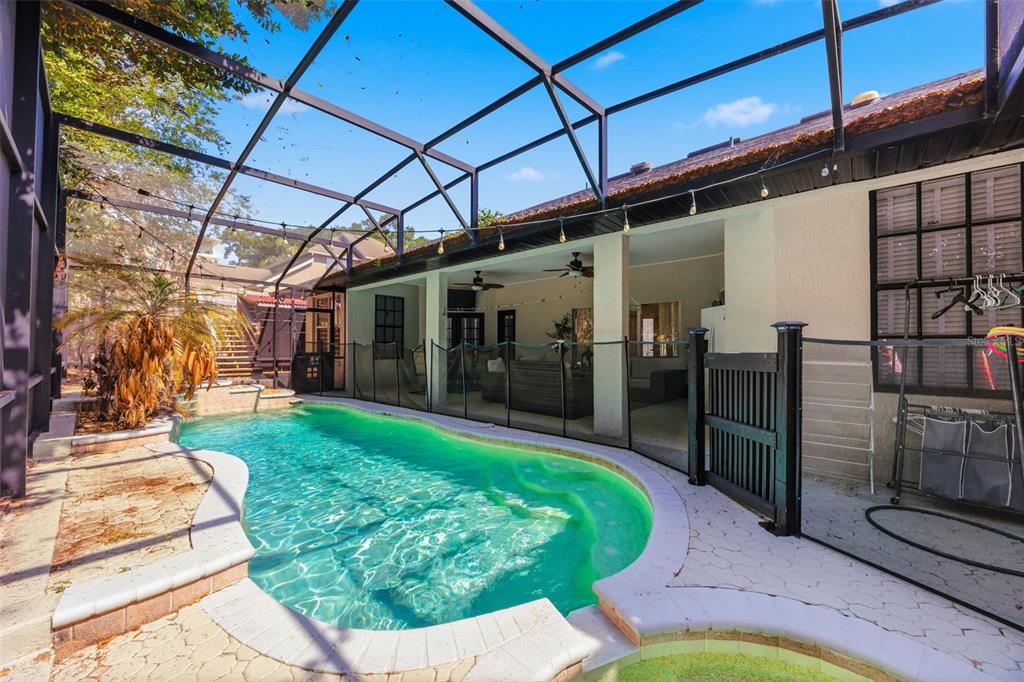 A screened-in swimming pool and patio area with a child safety fence and covered lanai — 13031 SUNSHINE VIEW COURT, CLERMONT, FL