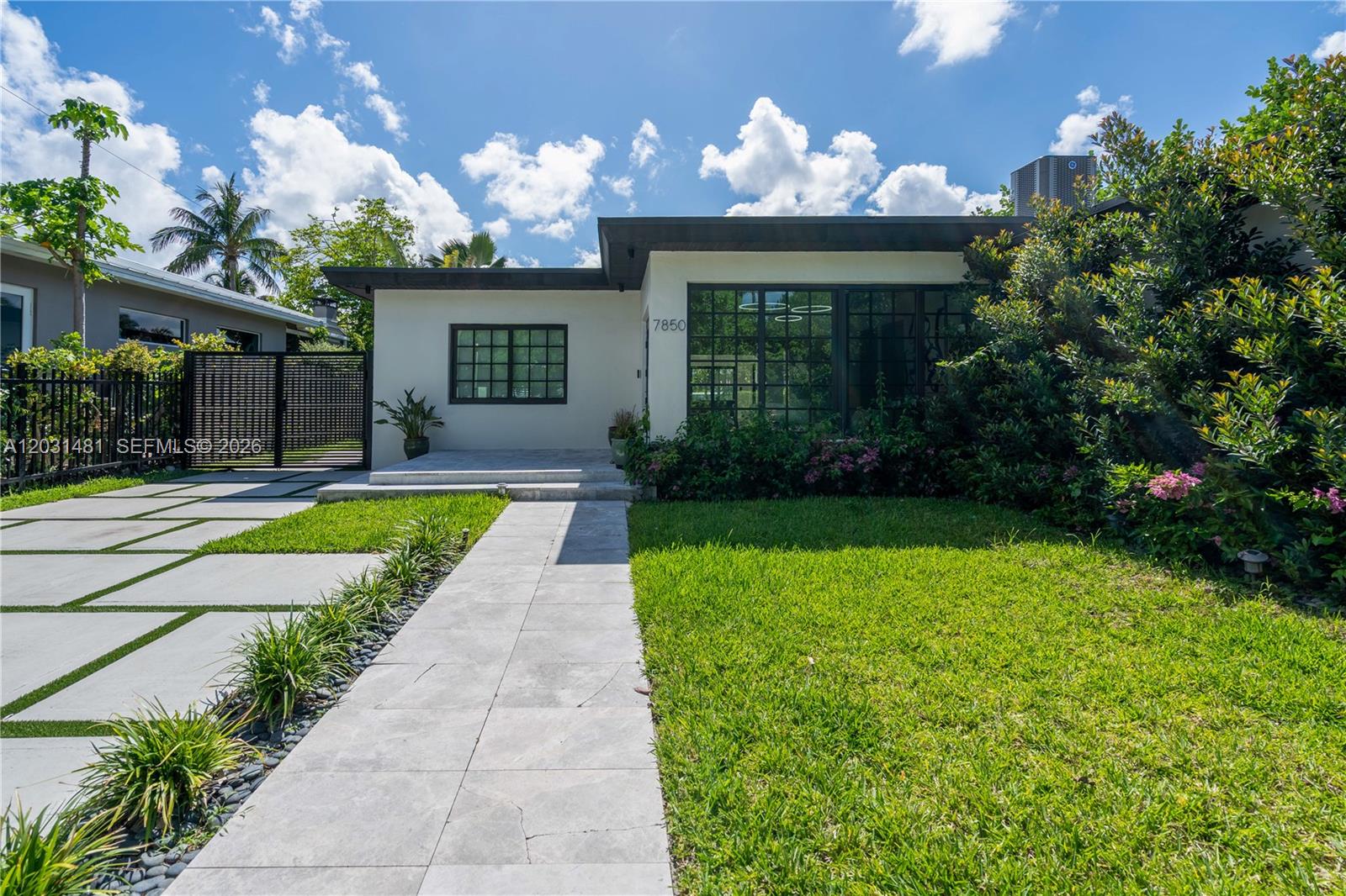 A modern single-story house features a flat roof, large grid windows, and a paved walkway — 7850 Hawthorne Ave, Miami Beach FL 33141, MIAMI BEACH, FL