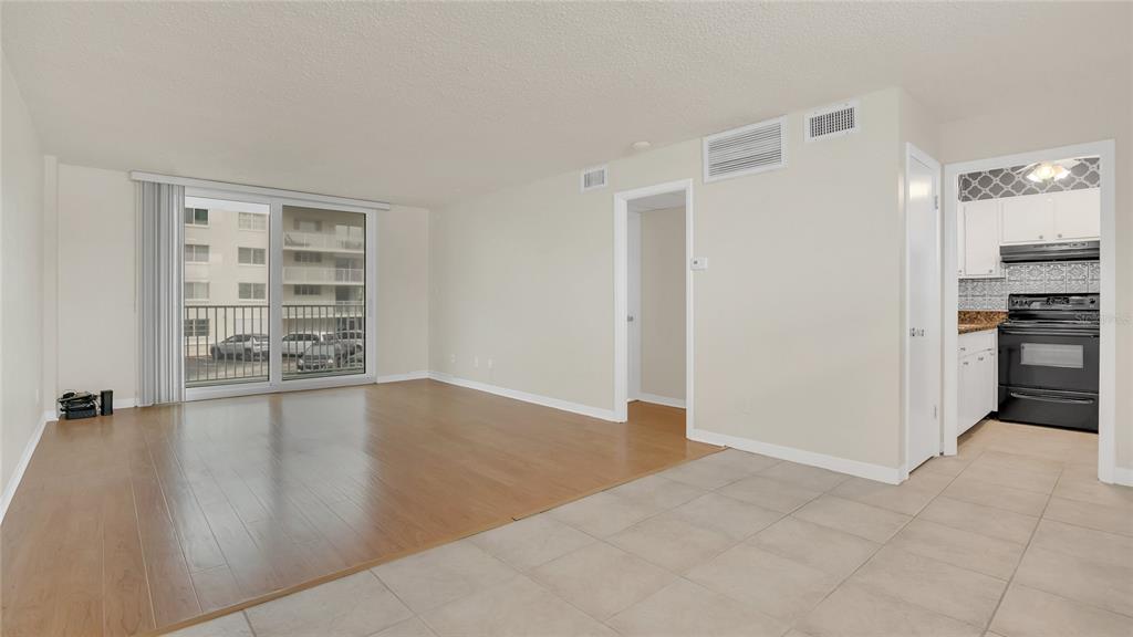 An interior view showing a living area with wood flooring, tile, and an adjacent kitchen — 2727 N ATLANTIC AVENUE UNIT 2020, DAYTONA BEACH, FL