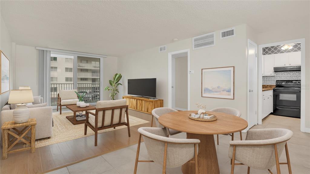 A living and dining area with light tile floors, a round table, and a balcony view — 2727 N ATLANTIC AVENUE UNIT 2020, DAYTONA BEACH, FL