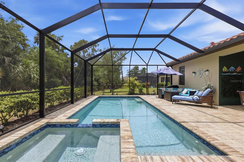 A rectangular swimming pool and attached spa are enclosed within a screened-in patio area — 20930 VALORE COURT, VENICE, FL