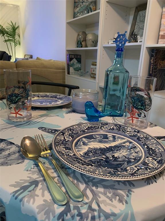 A dining table is set with blue and white patterned plates, glassware, and silverware — 10004 CORTEZ ROAD W UNIT 102, BRADENTON, FL