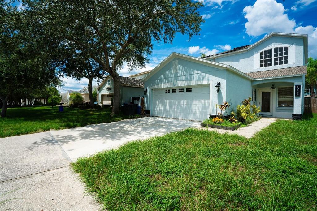 A light blue two-story house with a two-car garage and a concrete driveway — 10468 BLACKMORE DRIVE, TAMPA, FL