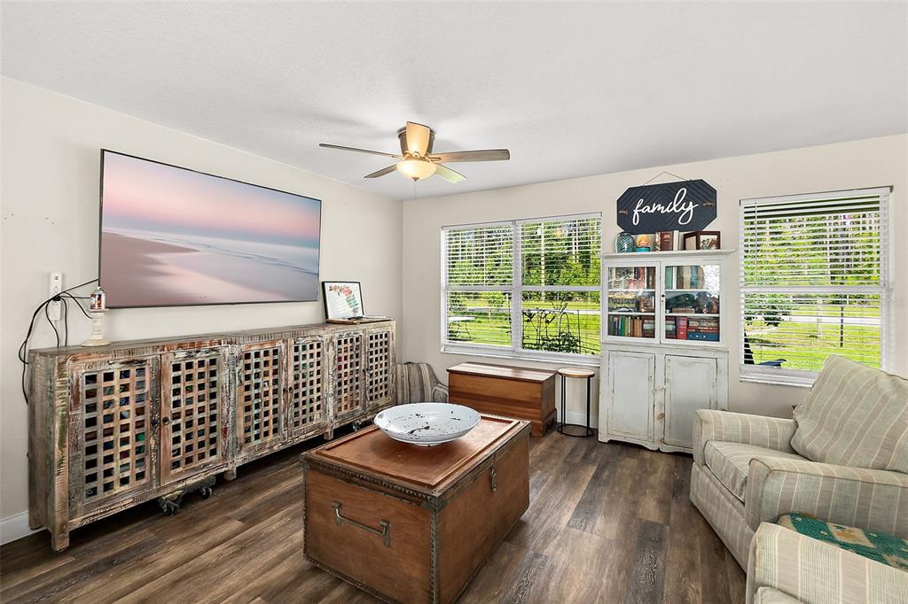 A living room features a large television, a wooden media console, and a coffee table — 1893 WATER OAK ROAD, BUNNELL, FL