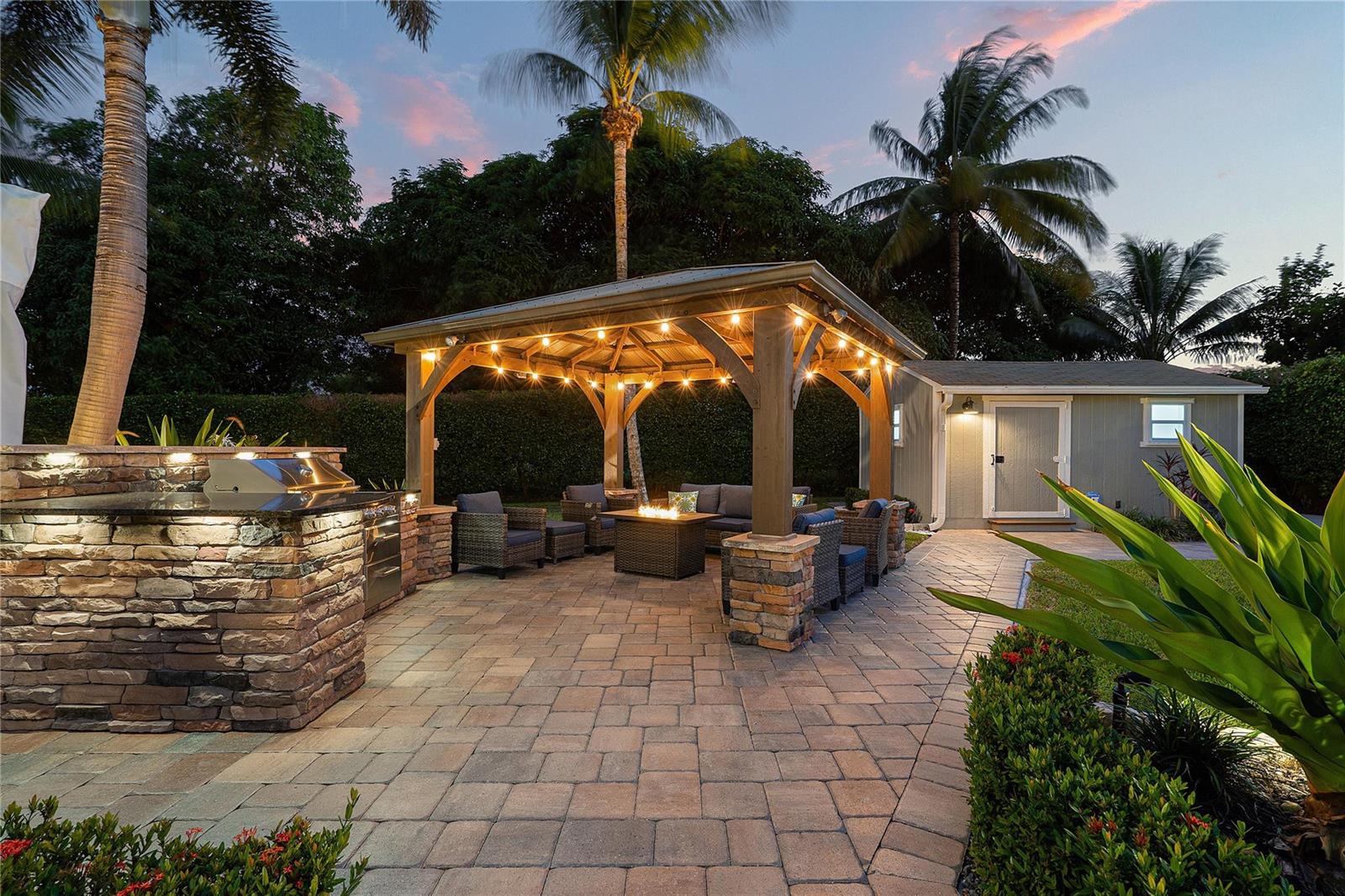 An outdoor patio features a stone grill island, a covered gazebo, and a fire pit — 112 SW 24th Avenue, Boynton Beach FL 33435, BOYNTON BEACH, FL