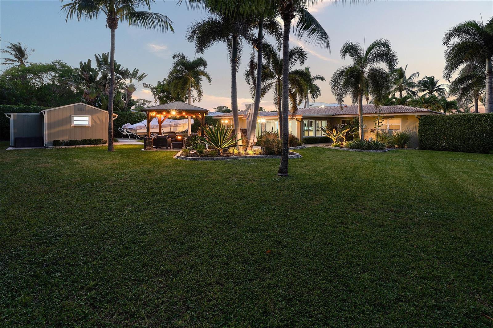 A backyard features a lawn, palm trees, a gazebo, a storage shed, and a house — 112 SW 24th Avenue, Boynton Beach FL 33435, BOYNTON BEACH, FL