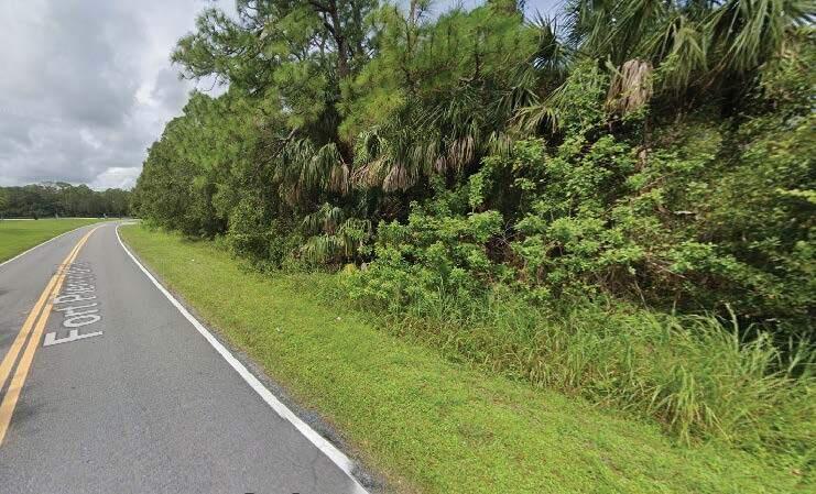 A paved road runs alongside a dense line of trees and shrubs in a grassy area — 8702 Fort Pierce Boulevard, Fort Pierce FL 34951, FORT PIERCE, FL