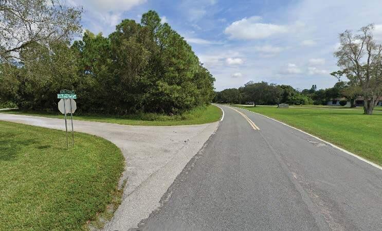 A paved road curves past a grassy intersection with a stop sign and street signs — 8702 Fort Pierce Boulevard, Fort Pierce FL 34951, FORT PIERCE, FL