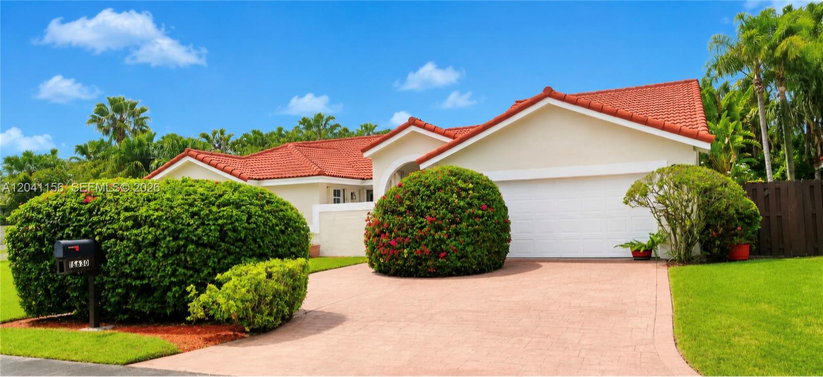 A single-story house with a red tile roof, white garage door, and large manicured shrubs — 15630 SW 46th Ter, Miami FL 33185, MIAMI, FL