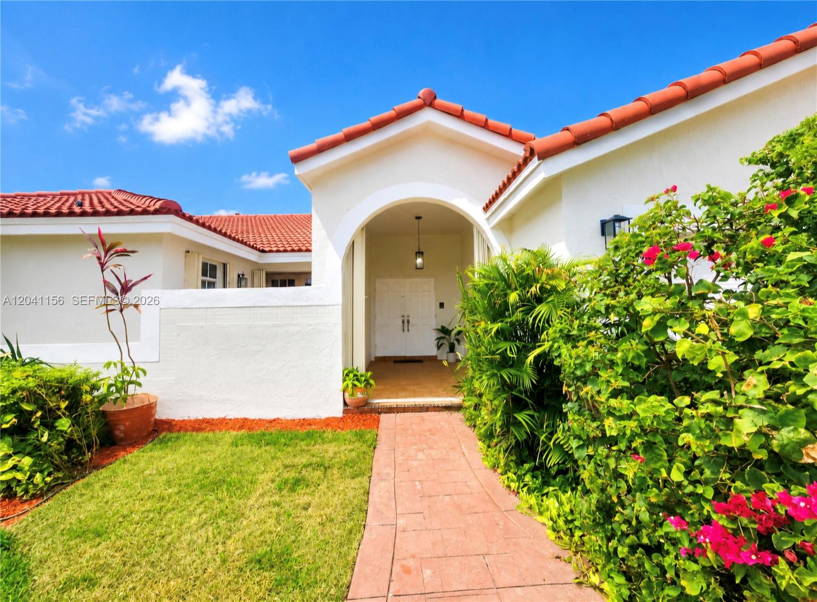 The exterior of a white house features a red tile roof and a brick walkway — 15630 SW 46th Ter, Miami FL 33185, MIAMI, FL