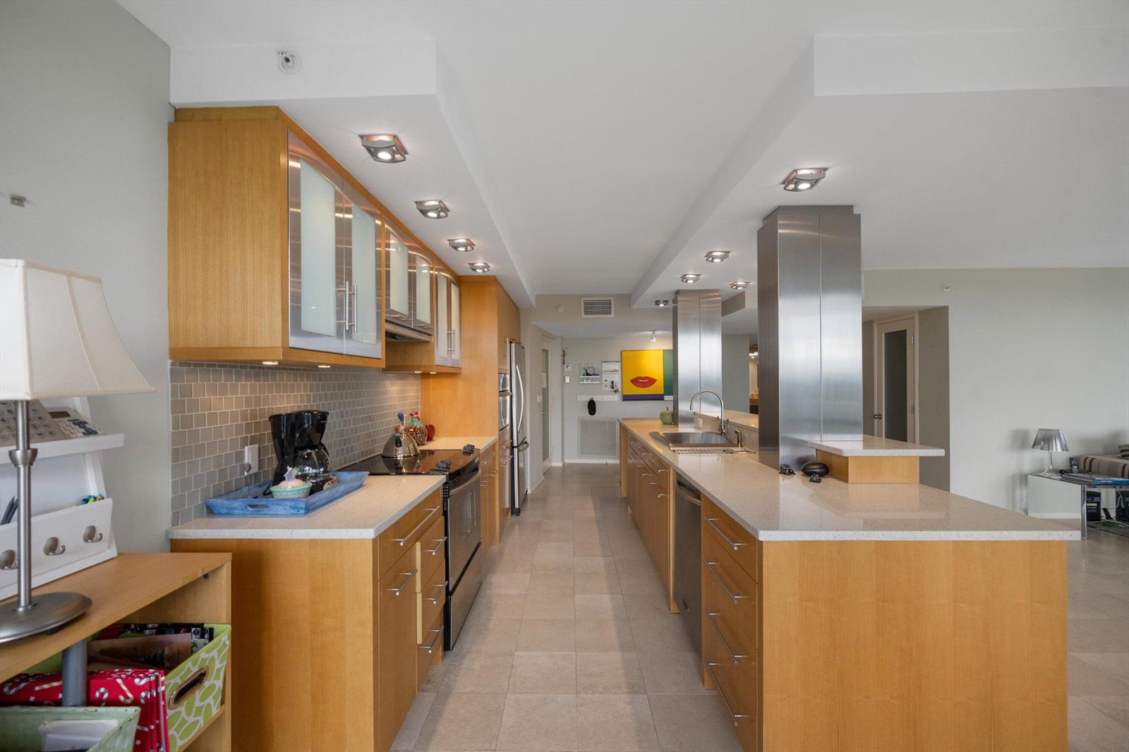 A modern kitchen features light wood cabinetry, stainless steel appliances, and a long island — 3360 S Ocean Boulevard # I, Palm Beach FL 33480, PALM BEACH, FL