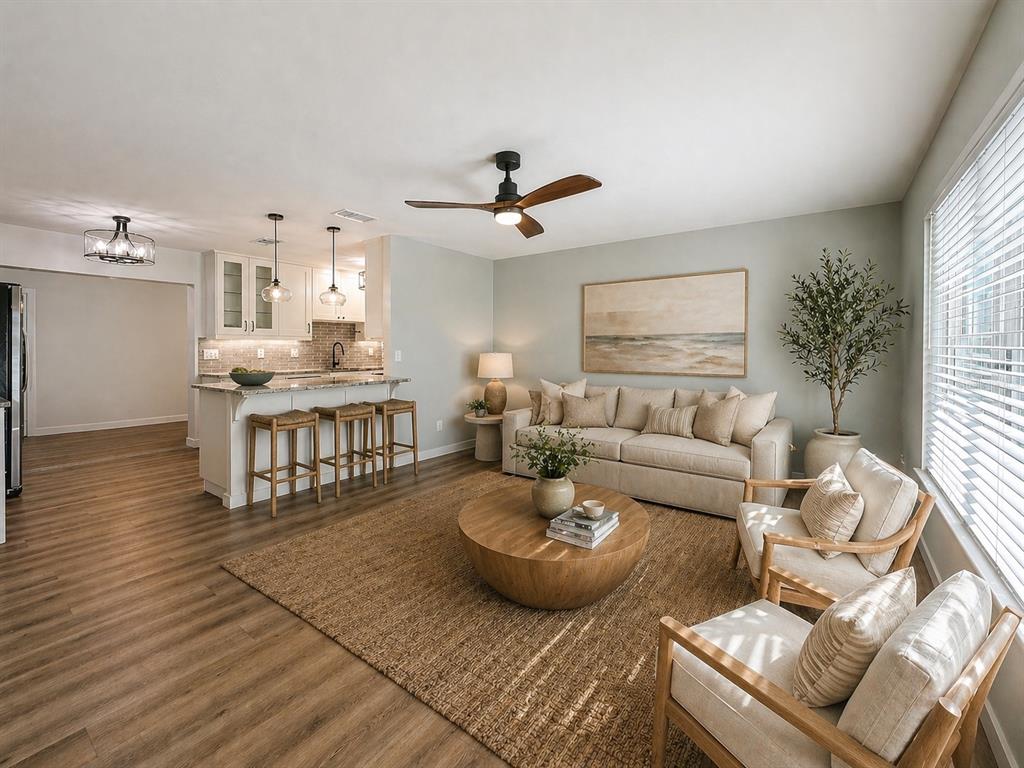 A living room with a beige sofa, two armchairs, a round coffee table, and kitchen island — 7610 117TH STREET, SEMINOLE, FL
