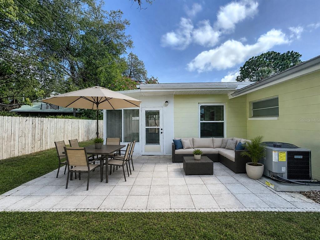 A paved patio features an outdoor dining set with an umbrella and a sectional sofa — 7610 117TH STREET, SEMINOLE, FL
