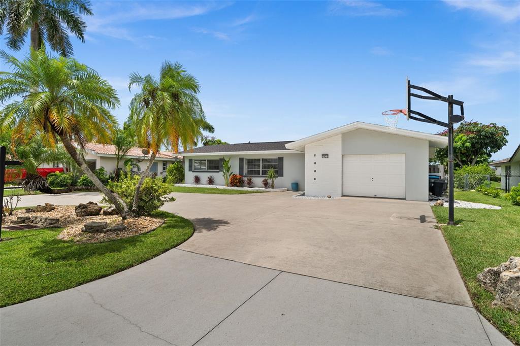 A single-story house with a white garage, a concrete driveway, and palm trees — 5122 SW 3RD AVENUE, CAPE CORAL, FL