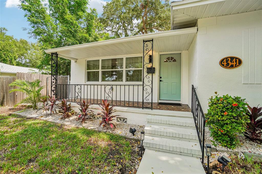 A white house exterior features a front porch with decorative iron railings and a light-colored door — 4341 1ST AVENUE N, ST PETERSBURG, FL