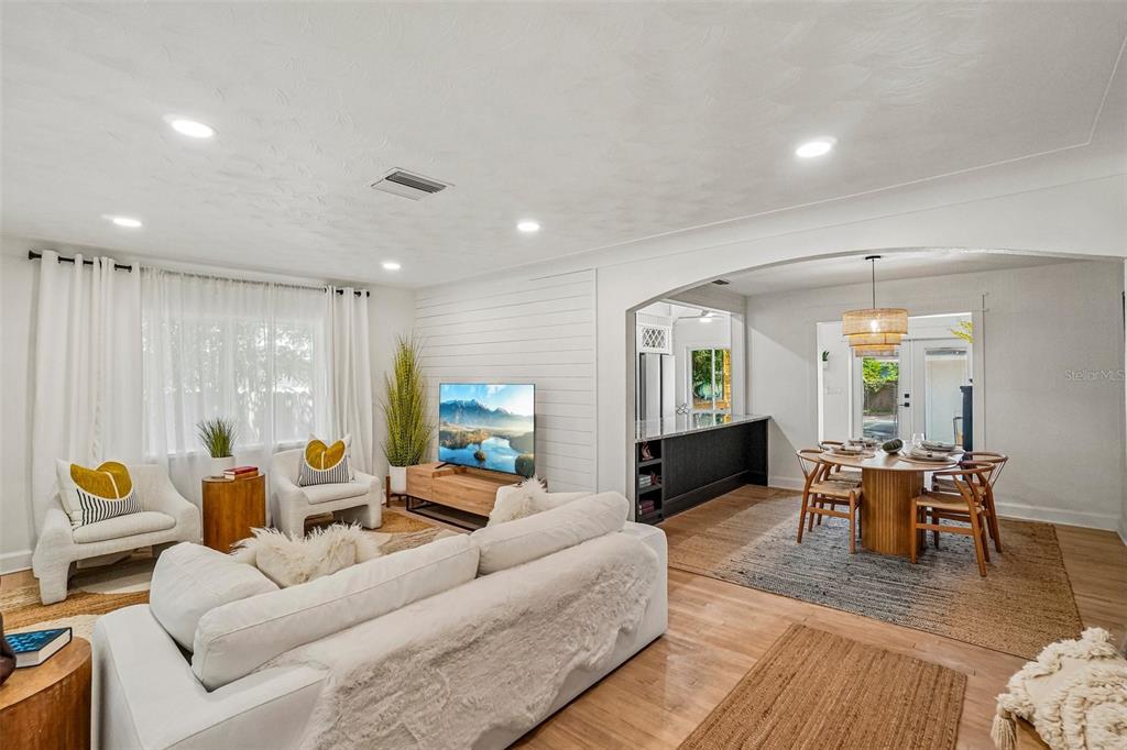 A living room with white walls, shiplap accent wall, and an open dining area — 4341 1ST AVENUE N, ST PETERSBURG, FL