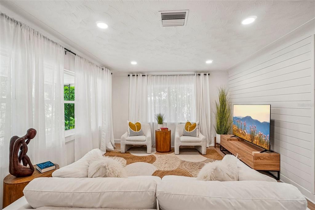 A living room features white shiplap walls, a white sofa, two armchairs, and sheer curtains — 4341 1ST AVENUE N, ST PETERSBURG, FL