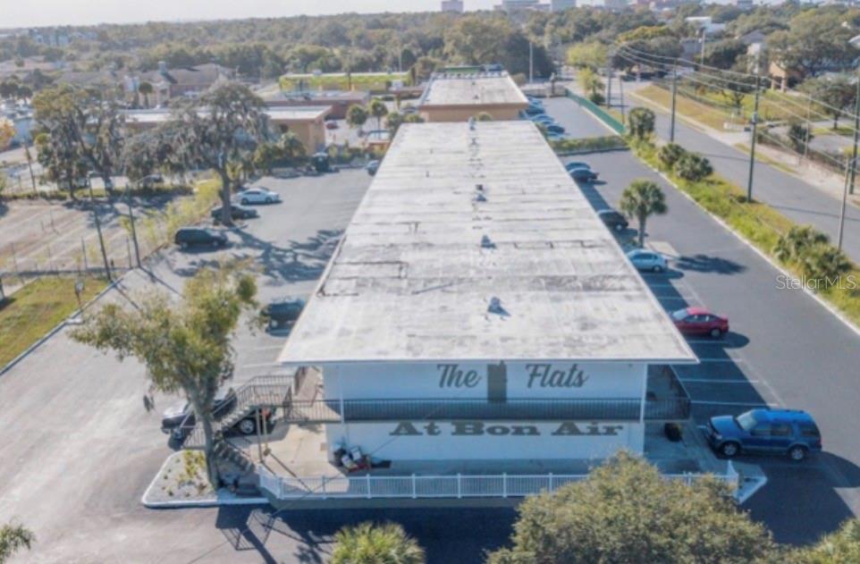 An aerial view of a long, rectangular apartment building with a flat roof and parking — 515 BON AIR STREET UNIT 160, LAKELAND, FL