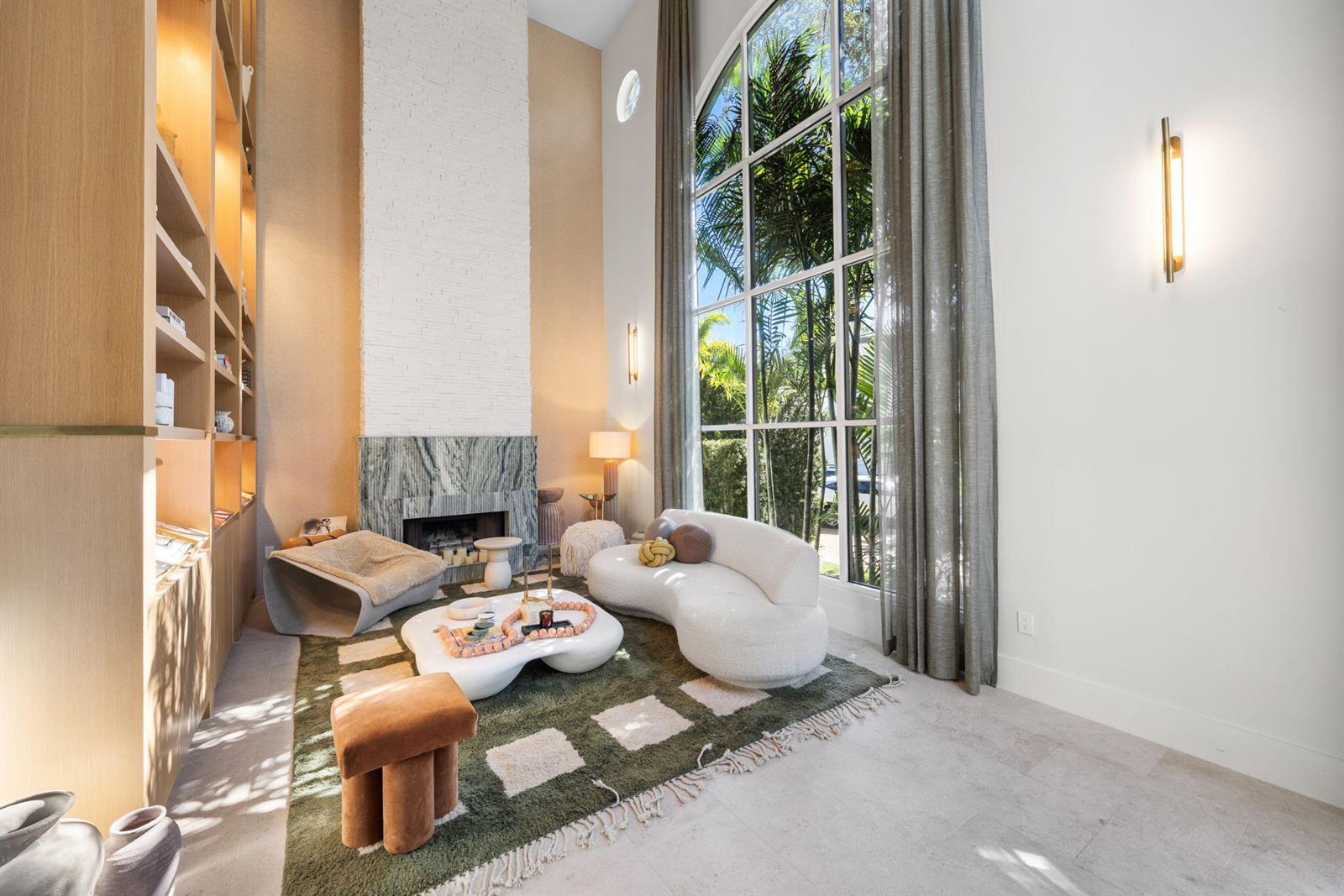 A living room features a tall white brick fireplace, floor-to-ceiling windows, and built-in shelving — 2765 Brickell Court, Miami FL 33129, MIAMI, FL