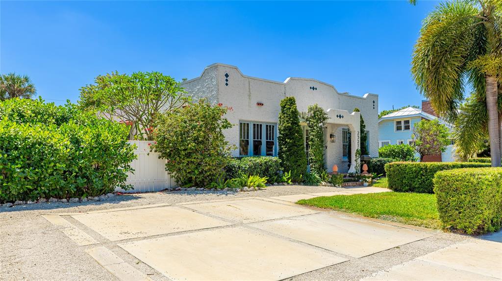 A white stucco house with a flat roof and a concrete driveway under a blue sky — 2327 7TH AVENUE W, BRADENTON, FL
