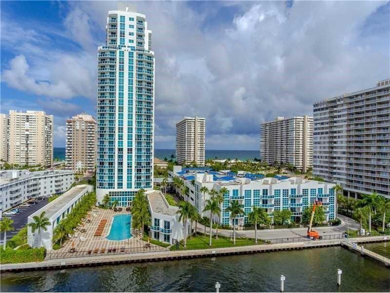 An aerial view shows a tall residential tower, a swimming pool, and surrounding apartment buildings — 1945 S Ocean Drive # 910, Hallandale Beach FL 33009, HALLANDALE BEACH, FL