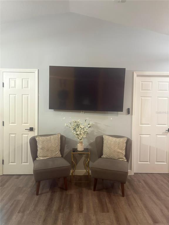 A wall-mounted television is positioned between two grey armchairs with a small table in between — 124 GUADALAJARA DRIVE, KISSIMMEE, FL