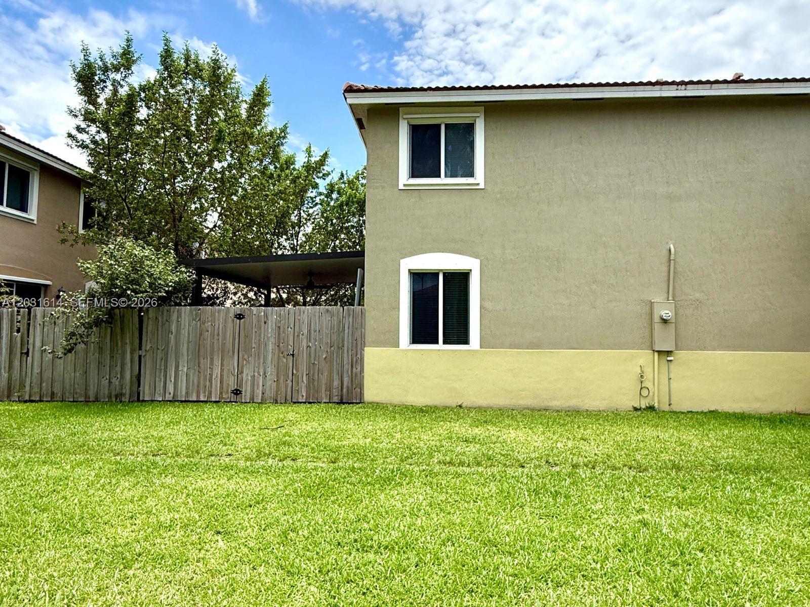 An open-concept kitchen and living area features dark wood cabinets, stainless appliances, and tile flooring — HOMESTEAD, FL